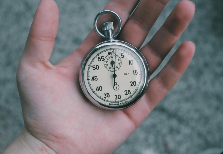 old mechanical stop watch on the palm of a hand