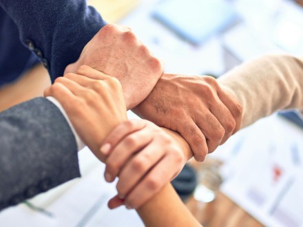 team holding hands in circle