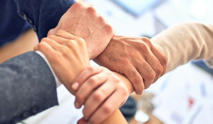 Group of business workers holding hands making a circle at the office